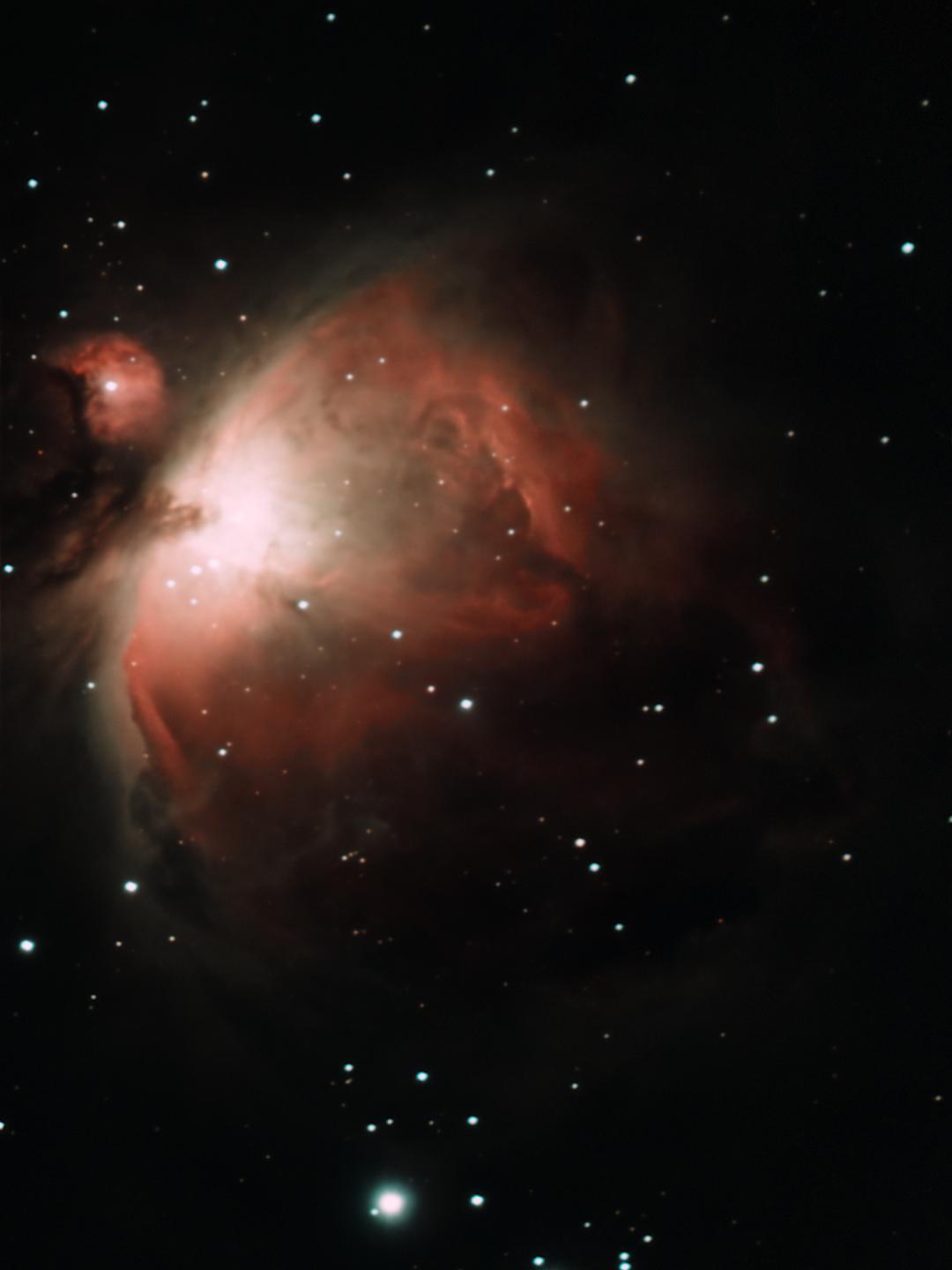 A cosmic image of the Orion Nebula, featuring glowing red and orange gas clouds against a black sky dotted with stars…