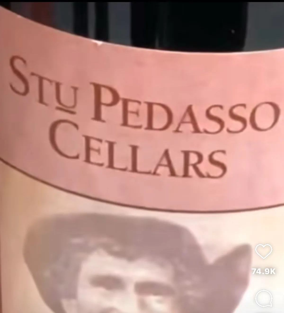 A close-up of a wine bottle label that reads 'Stu Pedasso Cellars' in brown serif font on a pink background, with a faded…