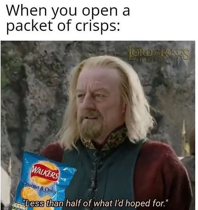 A man with long blonde hair and a beard, dressed in medieval-style clothing, holds a blue packet of Walkers Cheese & Onion…