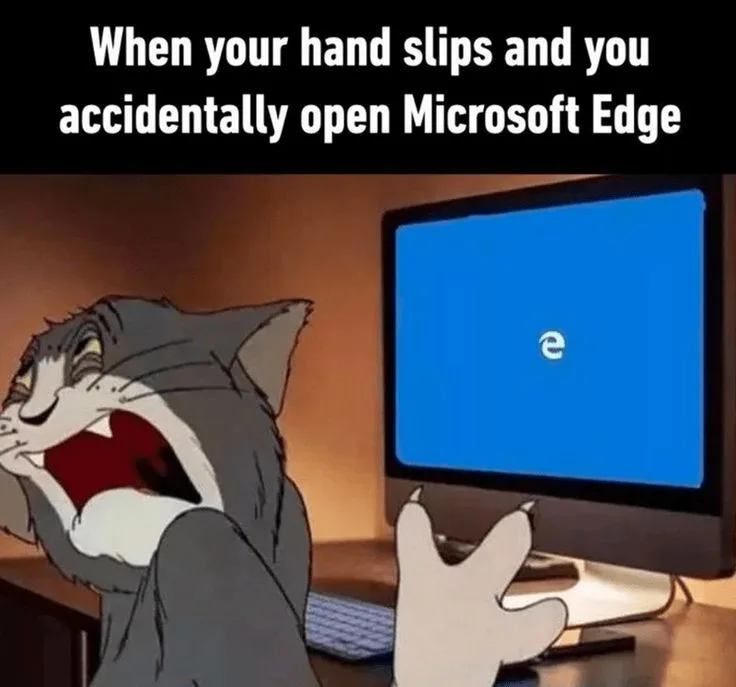 A cartoon cat, Tom from 'Tom and Jerry', is shown screaming in horror while looking at a computer monitor displaying the…