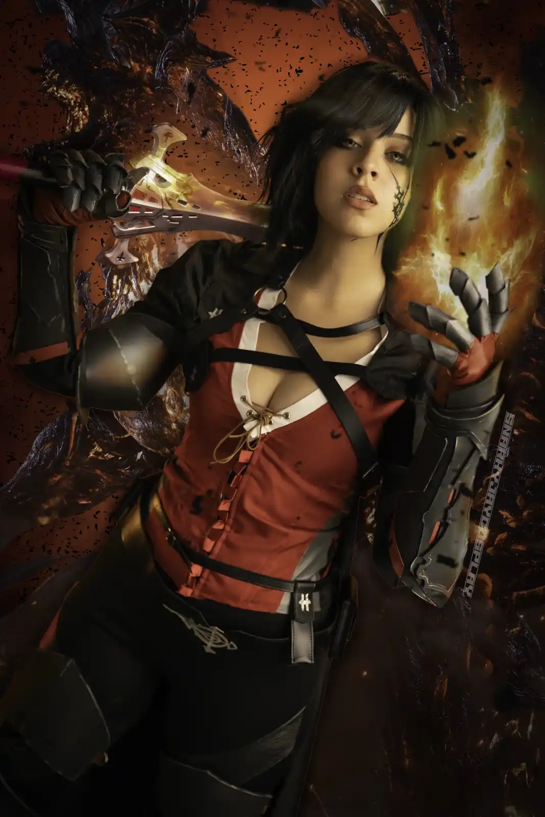 A cosplayer dressed as a fantasy warrior with dark hair, holding a glowing sword and a flaming gauntlet, set against a…
