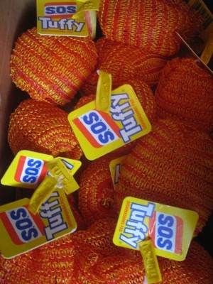 A close-up shot of numerous orange and yellow braided rope balls, each with a yellow tag that reads 'SOS Tuffy' in red and…