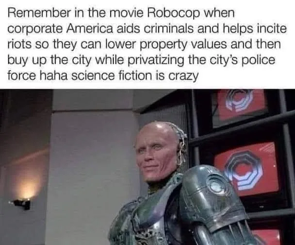 A still image of the character Robocop from the movie, showing his robotic arm and partial face, with overlaid text that…