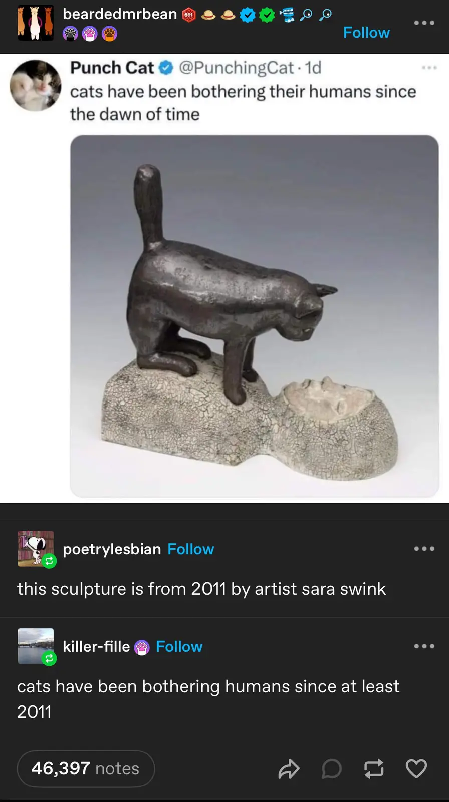 A dark bronze sculpture depicts a cat standing on the back of a human figure whose head is crushed into the base. The…