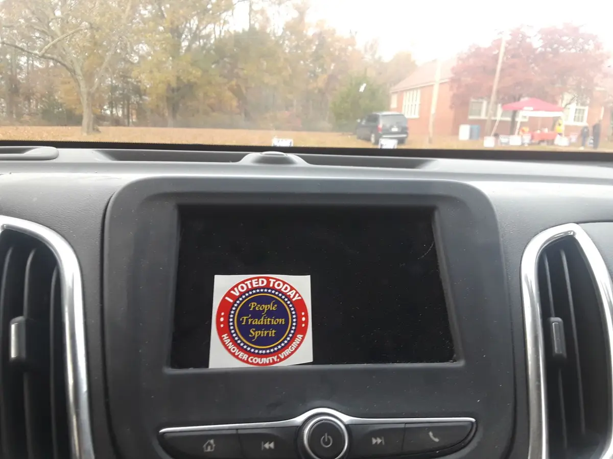 A photo taken from inside a car shows a circular 'I VOTED TODAY' sticker from Hanover County, Virginia, stuck on the car's…
