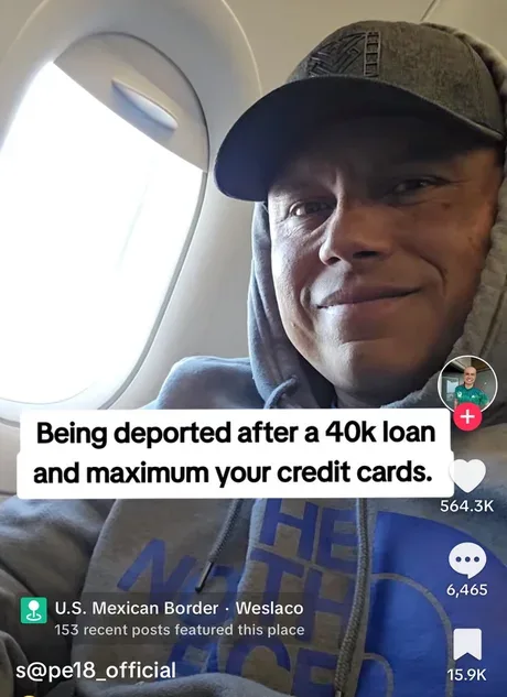 A man wearing a grey hoodie and baseball cap smiles while seated on an airplane, looking out the window. A white text box…