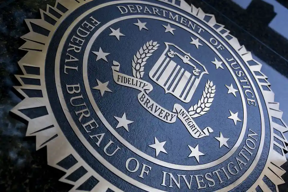 A close-up photograph of the official seal of the Federal Bureau of Investigation, featuring a blue circular emblem with…