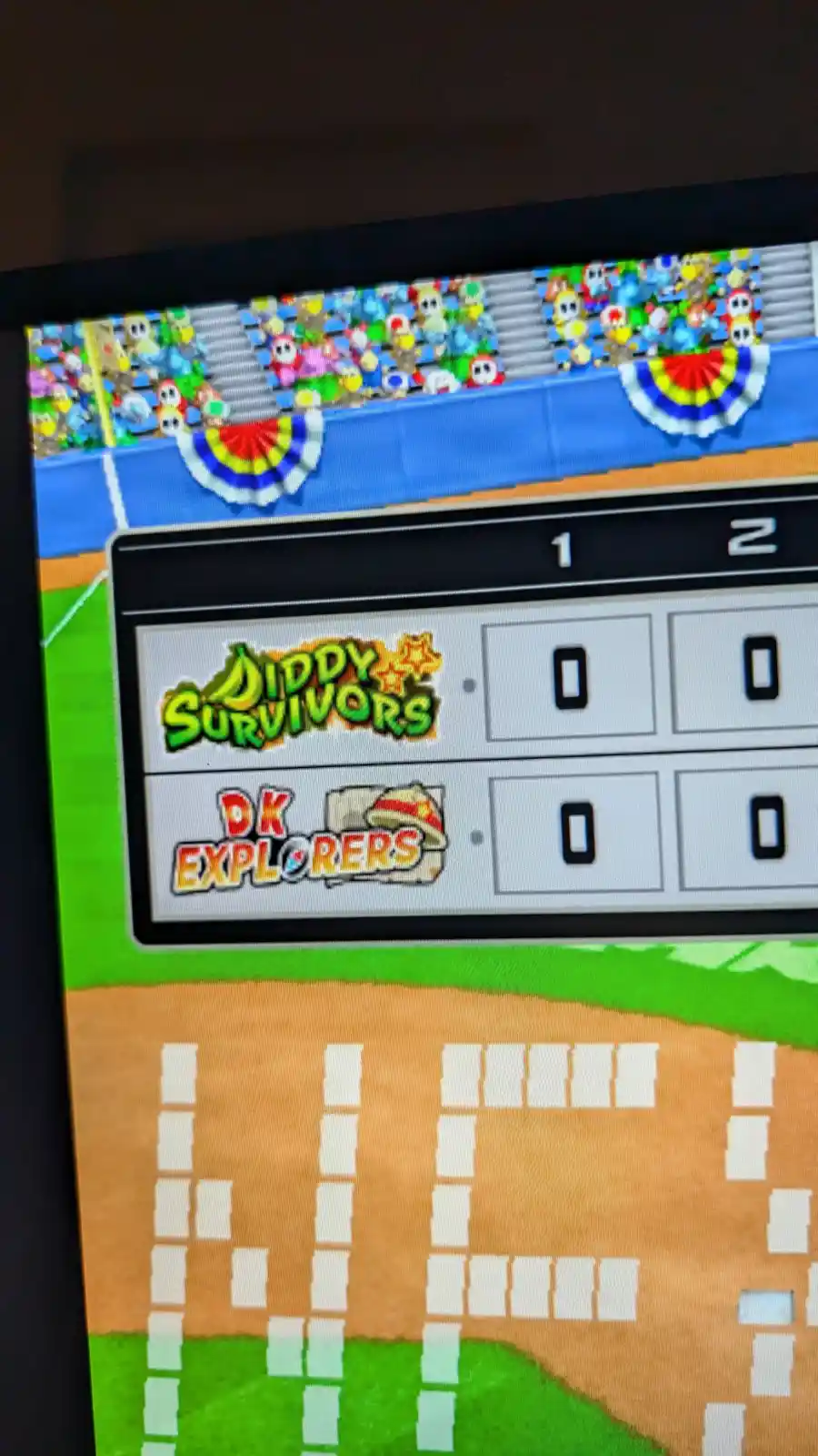 A screenshot from a Mario Kart-style game shows a scoreboard with two teams: 'Diddy Survivors' and 'DK Explorers', both at…