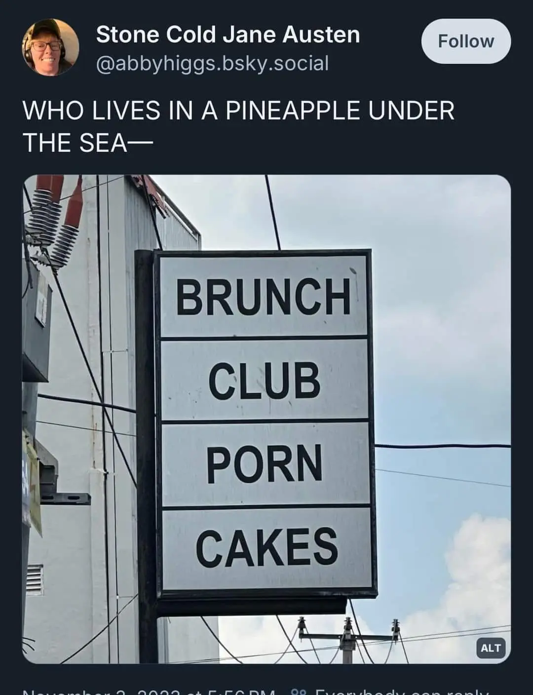 A photo of a vertical sign with four black-lettered white panels reading 'BRUNCH', 'CLUB', 'PORN', and 'CAKES'. Above the…