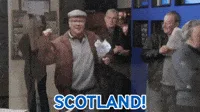 A man in a brown jacket and flat cap is shown in six identical frames, enthusiastically raising his right fist and shouting…