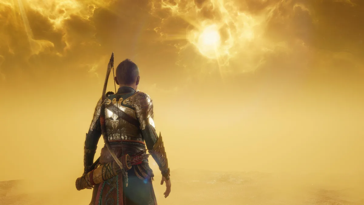 A video game character viewed from behind, wearing ornate armor and carrying a bow, stands in a vast desert under a golden…
