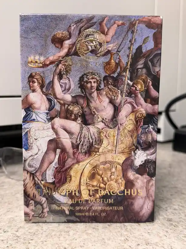 A perfume box for 'Triumph of Bacchus' by Argos features a classical painting of the Roman god Bacchus in a golden chariot…