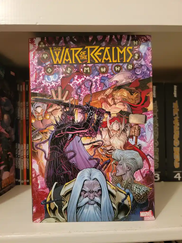 A comic book titled 'The War of the Realms' by Marvel sits on a white shelf, surrounded by other comics. The cover art…