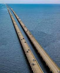 An aerial view of a long, straight bridge over water with cars driving on it. The image has text overlaid that reads 'i'm…