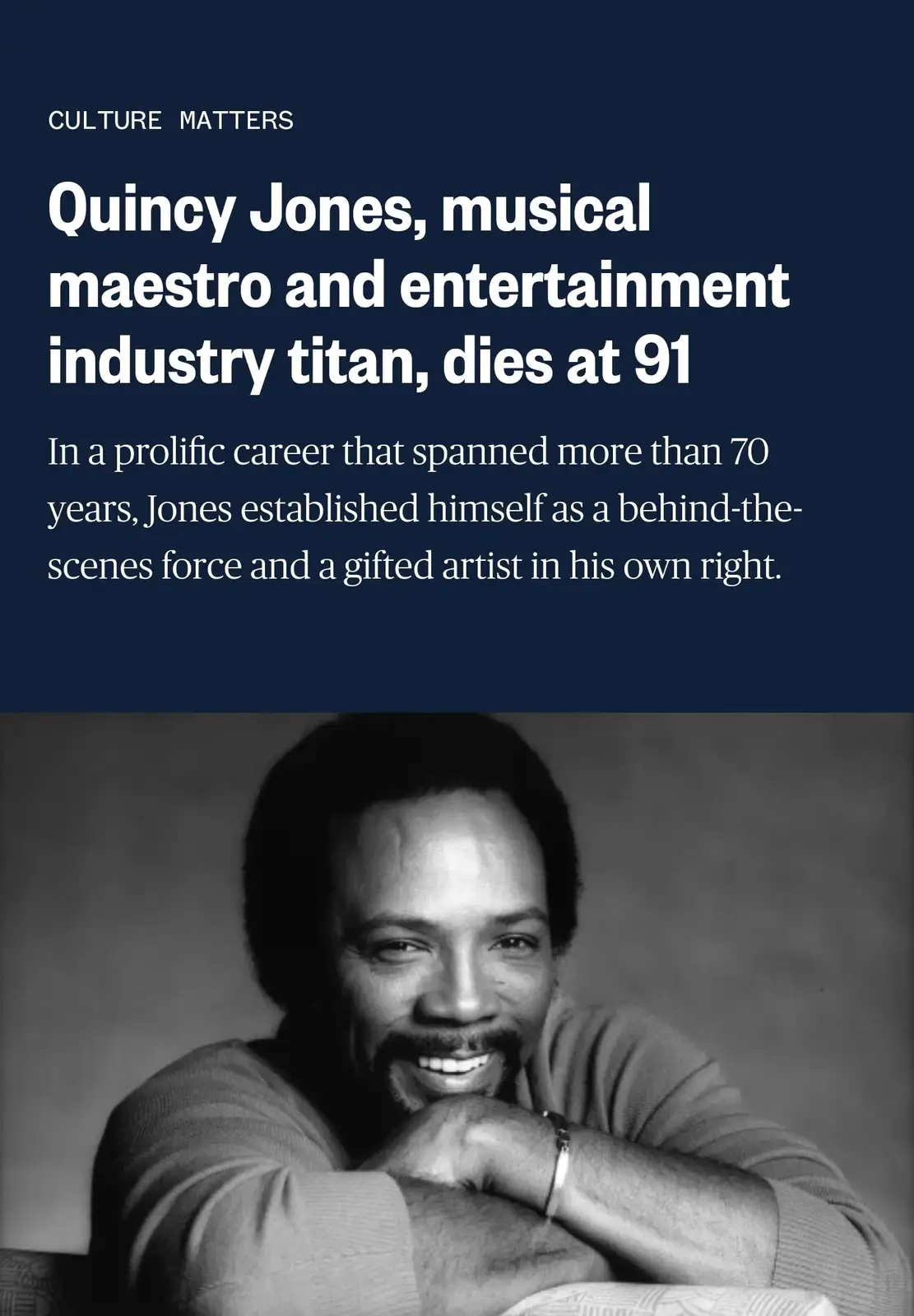 The image displays a black-and-white portrait of Quincy Jones smiling with his chin resting on his hands. Above the photo is…