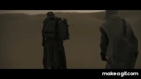 A sequence of frames shows a person in a long robe walking away across a desert, gradually revealing another person walking…