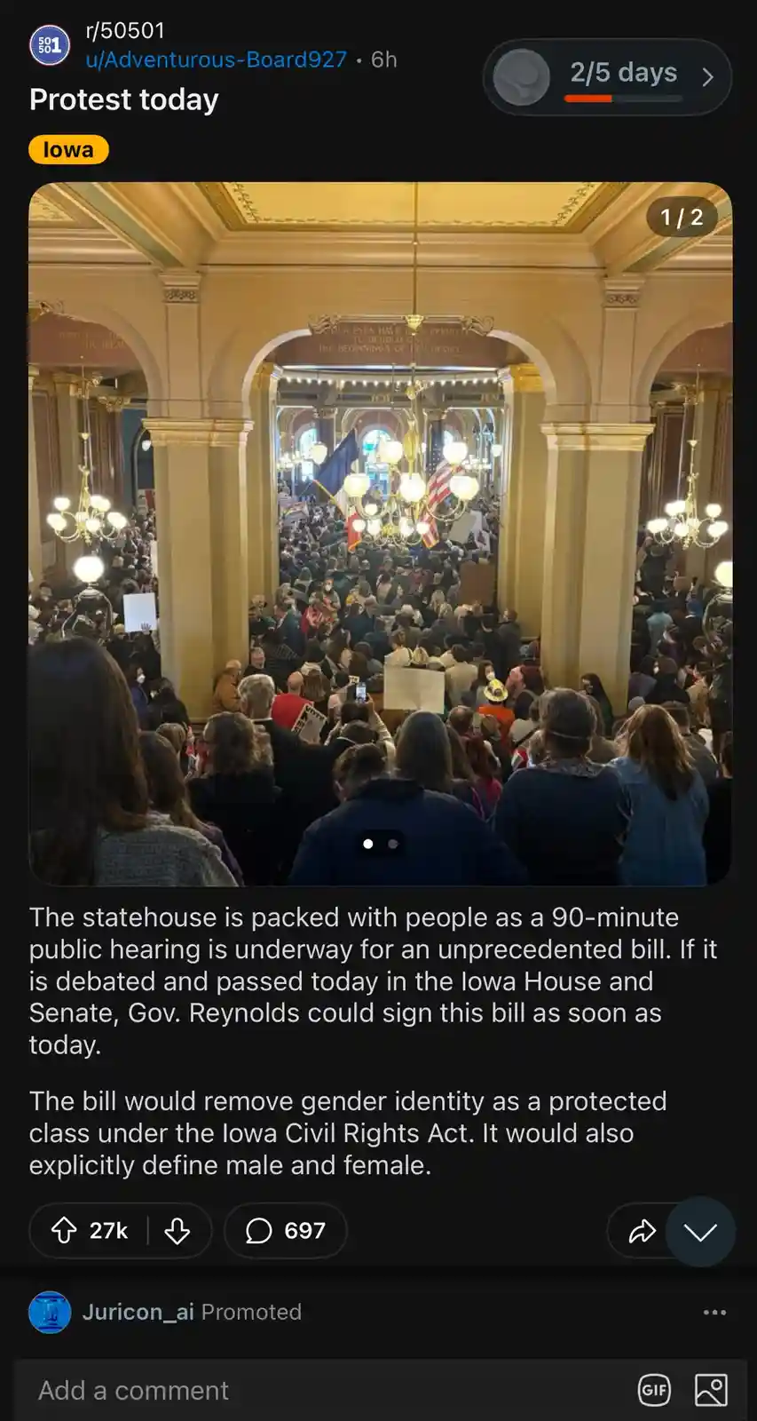 A crowded protest fills the ornate interior of the Iowa statehouse, with people holding signs and flags under chandeliers…