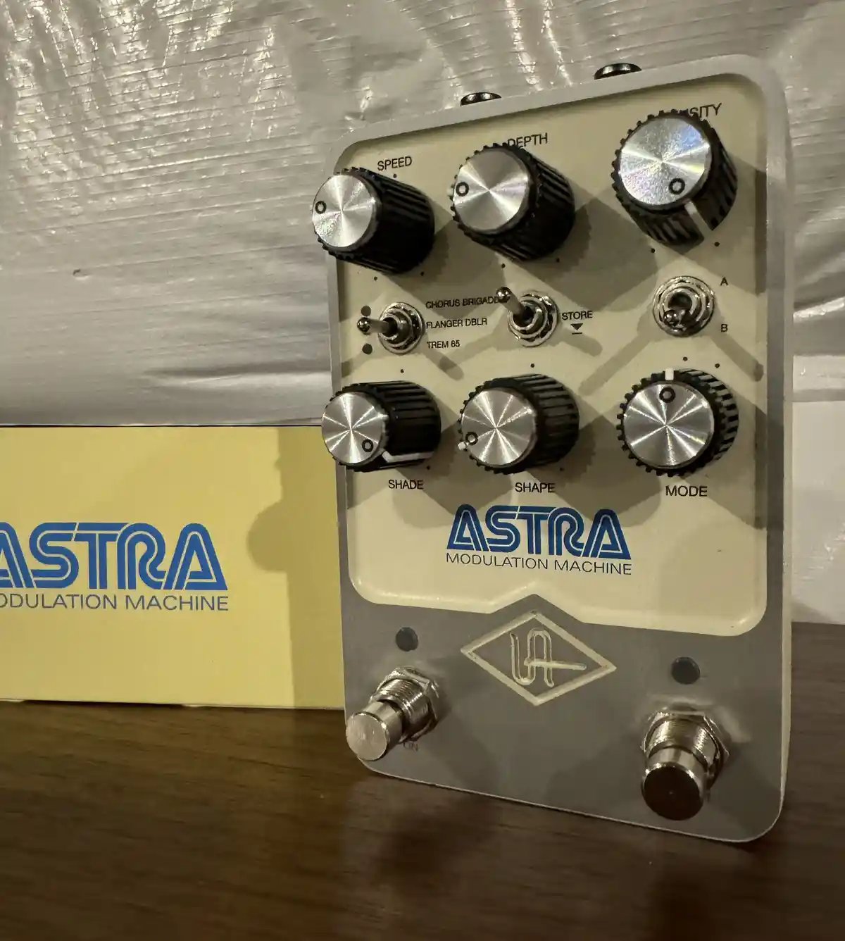 A close-up photo of a vintage-style guitar effects pedal labeled 'ASTRA MODULATION MACHINE' with multiple knobs and…