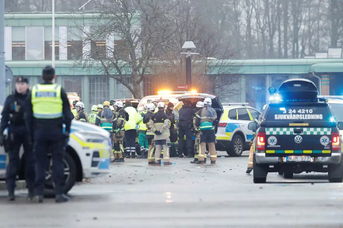 A chaotic emergency scene with police, firefighters, and paramedics gathered around vehicles, including a black Volkswagen…