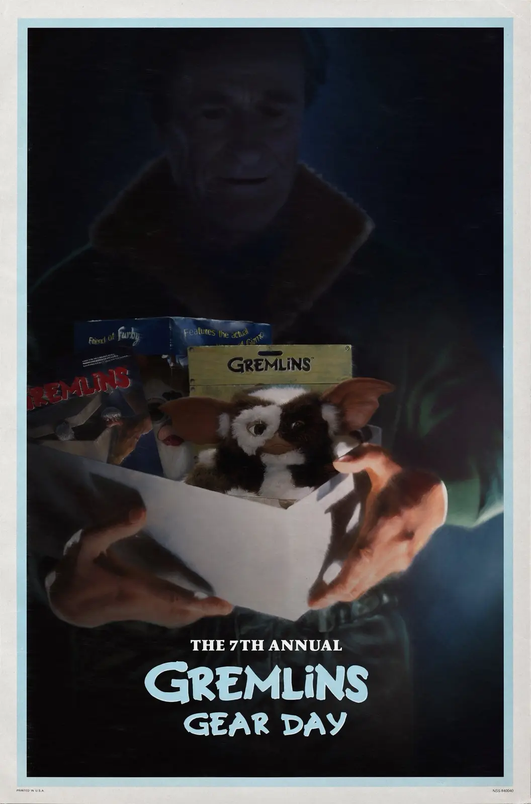 A person holds a box containing a Gizmo plush toy and other Gremlins merchandise, with a faded image of a man in the…
