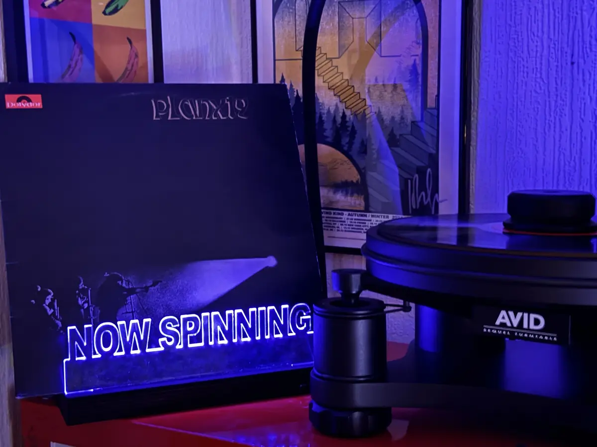 A vinyl record player with an 'AVID' brand turntable is shown next to a 'Planxty' album cover from the 'Dolydor' label. The…