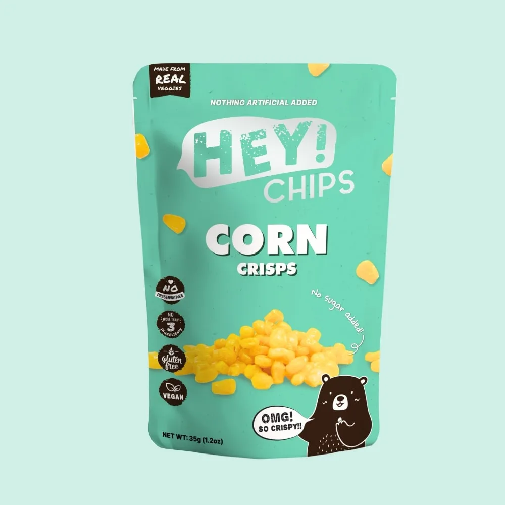 A teal bag of 'HEY! CHIPS' corn crisps features a cartoon bear exclaiming 'OMG! SO CRISPY!!' while surrounded by yellow corn…