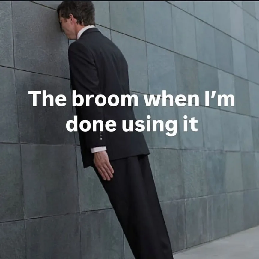 A man in a dark suit leans his head and upper body against a gray tiled wall, appearing exhausted or defeated. White text…