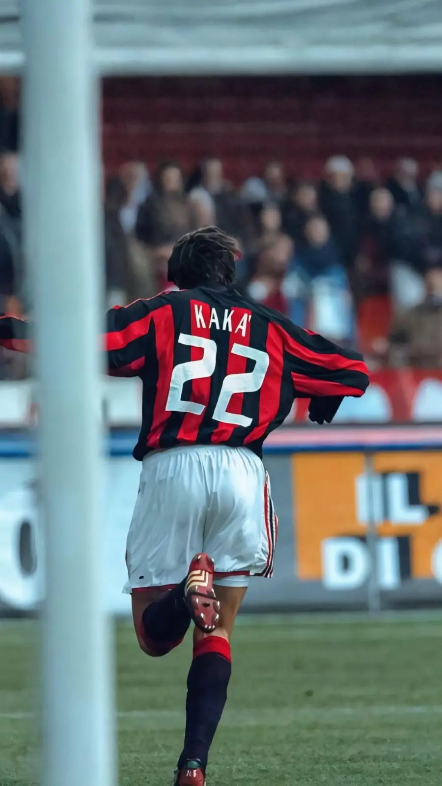 A soccer player wearing a black and red striped jersey with 'KAKA' and the number '22' on the back is seen from behind…