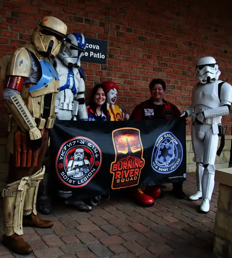 Five people in Star Wars costumes — including a clone trooper, a stormtrooper, and a person in a Ronald McDonald costume…