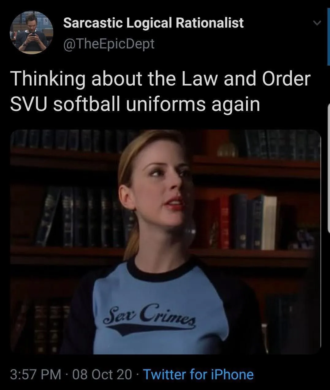 A woman with blonde hair tied back wears a light blue and black raglan shirt with 'Sex Crimes' printed in cursive on the…