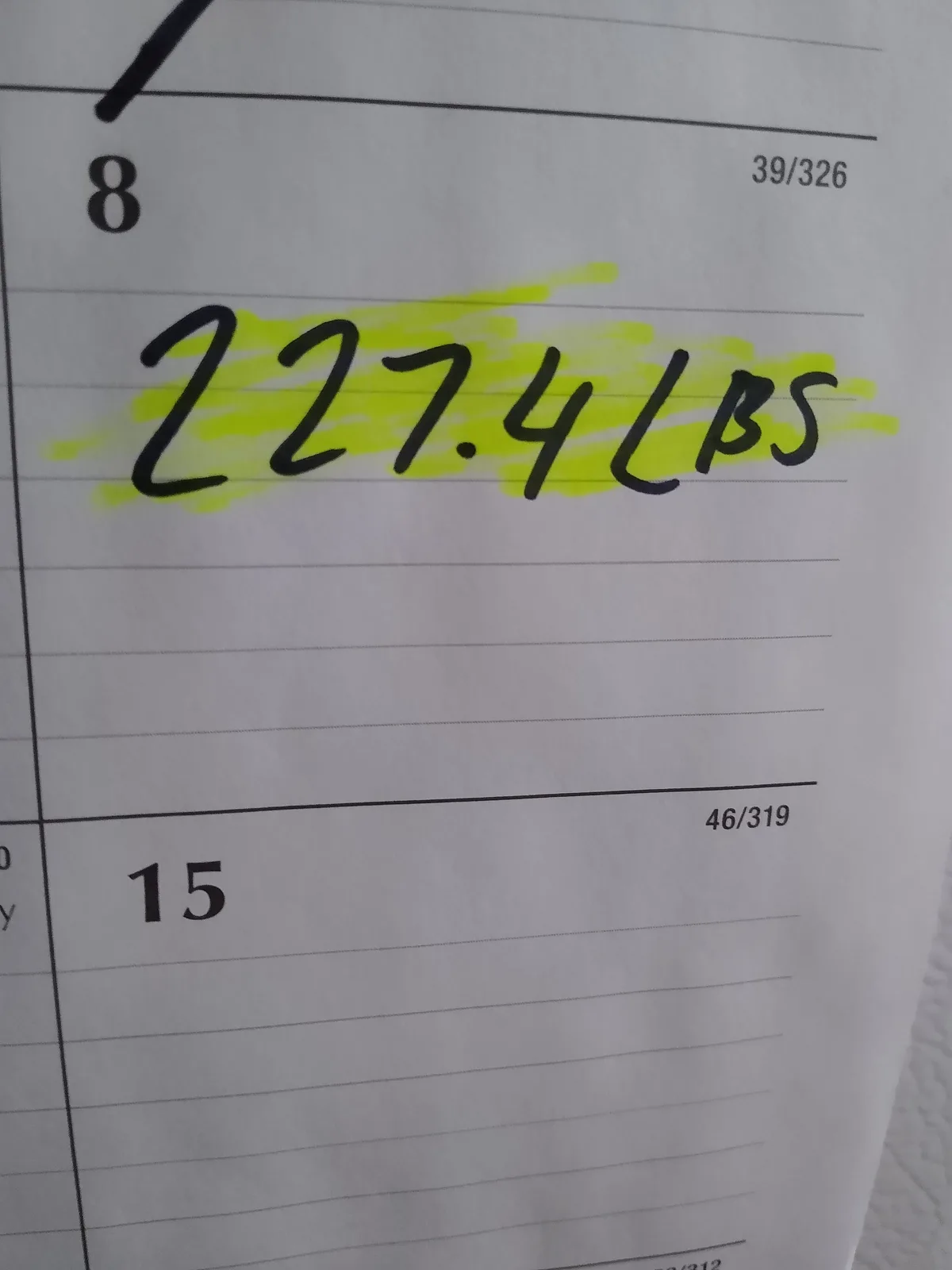 A close-up of a lined worksheet with handwritten text '227.4 LBS' highlighted in yellow. Above it, the number '8' is…