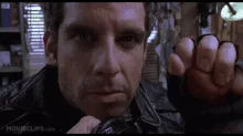 A six-frame sequence shows actor John Travolta in a dark leather jacket, initially holding up his clenched fist with a…