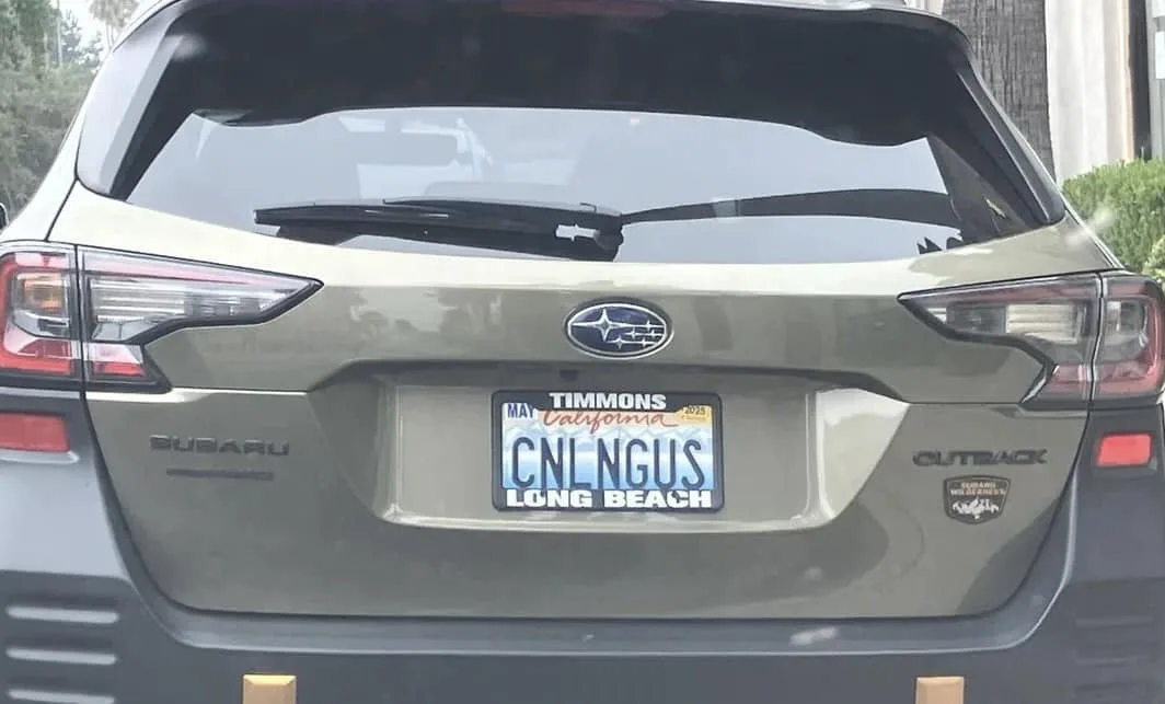 The rear of a green Subaru Outback shows a California license plate with the registration name 'TIMMONS' and the plate…
