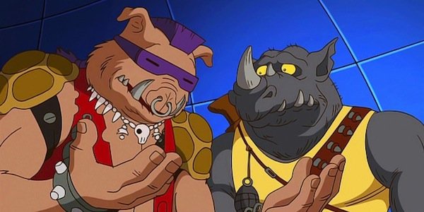 Two animated anthropomorphic characters, one pig-like with a purple mask and red outfit, the other rhino-like with a yellow…