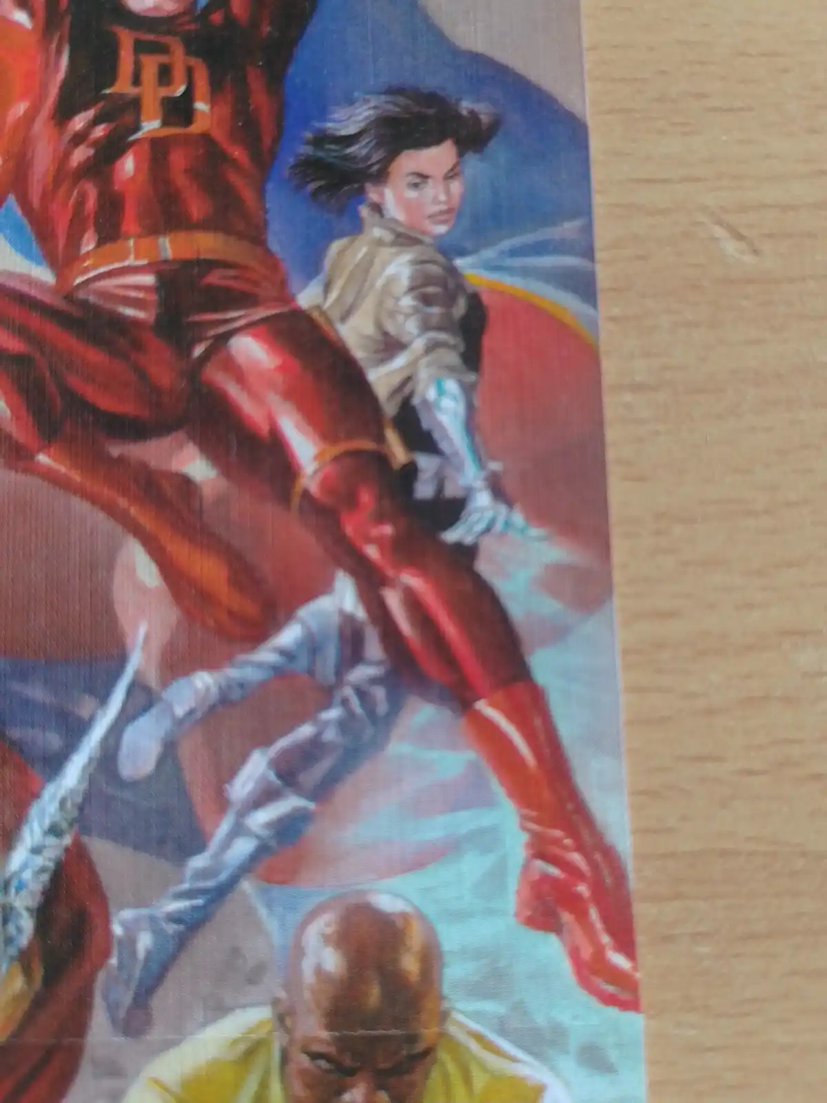 A comic book illustration shows a superhero in a red suit with a 'D' emblem mid-kick, while a woman in a beige outfit is…