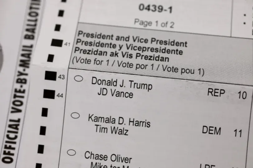 A close-up of an official mail-in ballot showing the president and vice president section with three candidate pairs. The…