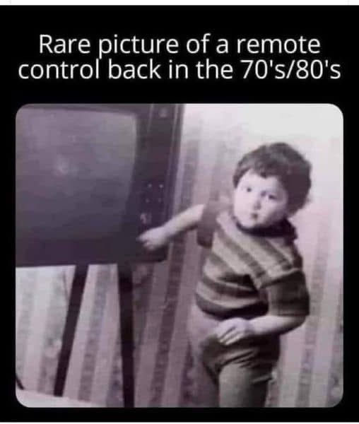 A grainy, black-and-white photo shows a young child standing beside an old, boxy television set from the 70s or 80s. The…