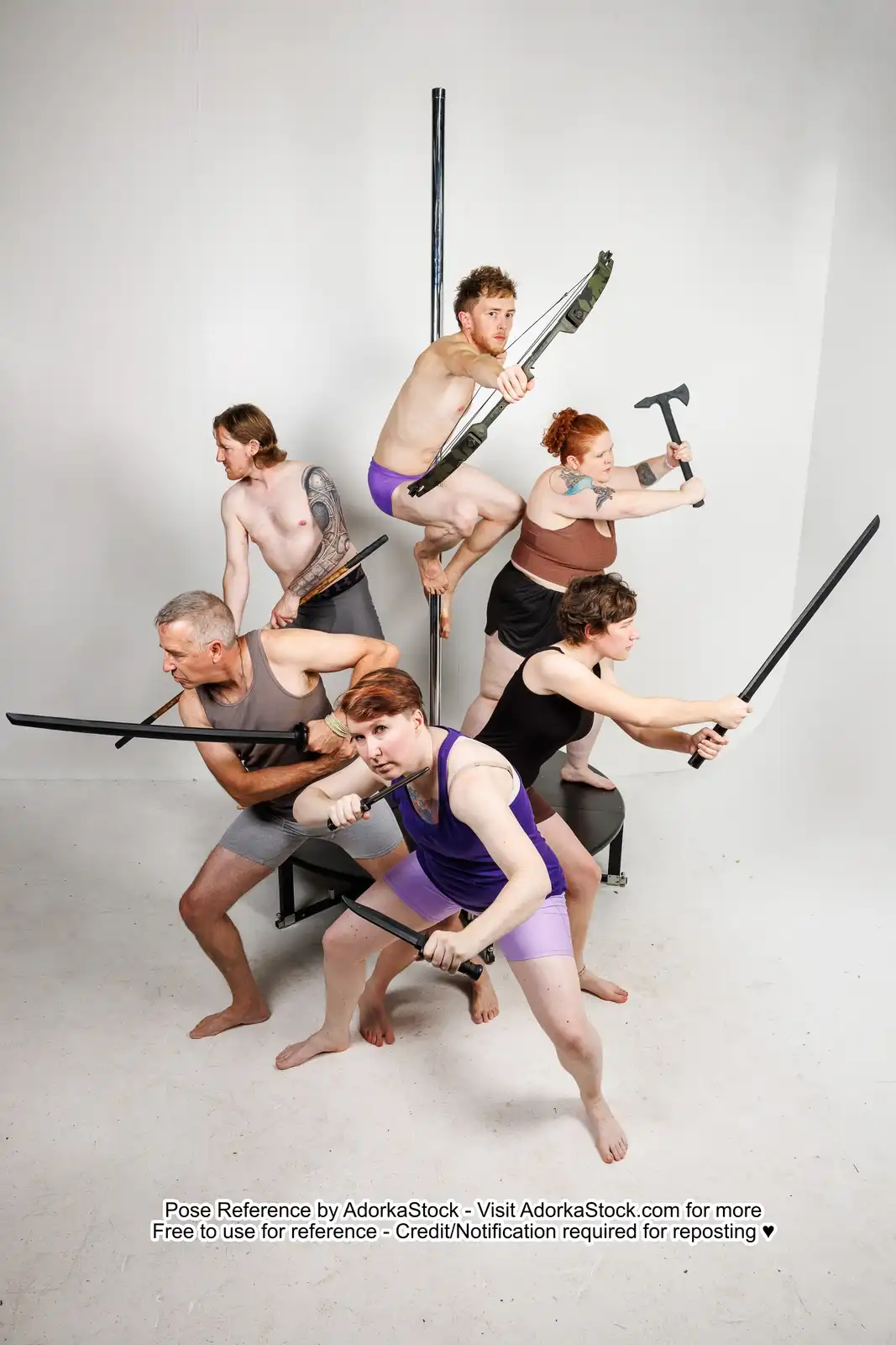 Six people in underwear and tank tops pose aggressively with various weapons like swords, knives, axes, and bows in a stark…