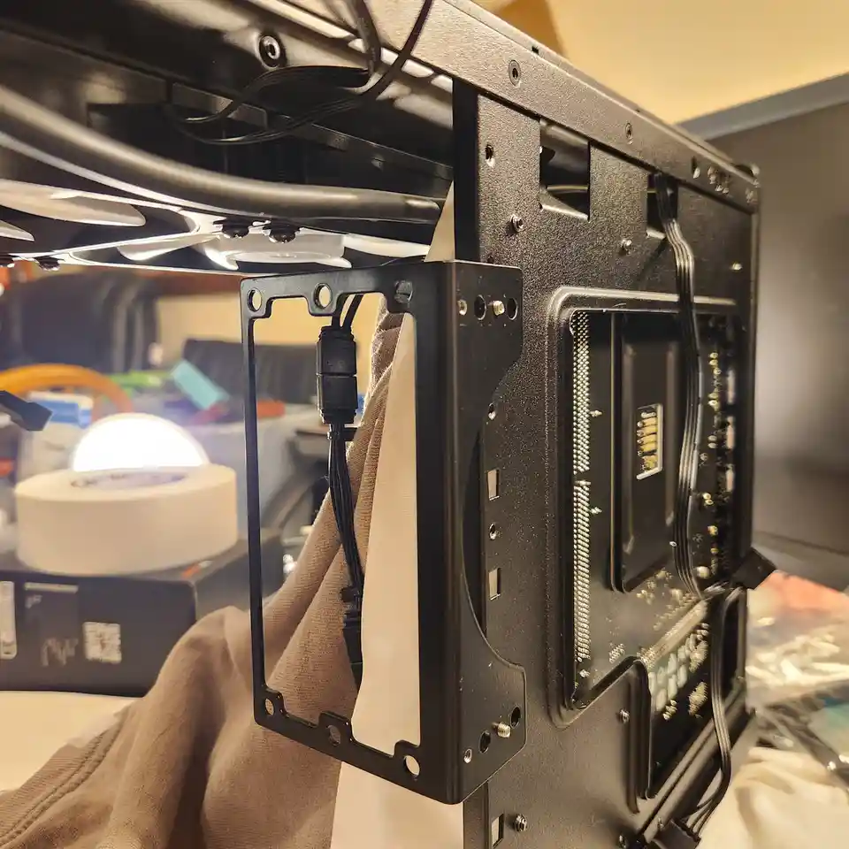 A close-up photo shows the inside of a black computer case with a partially installed graphics card, its metal bracket…