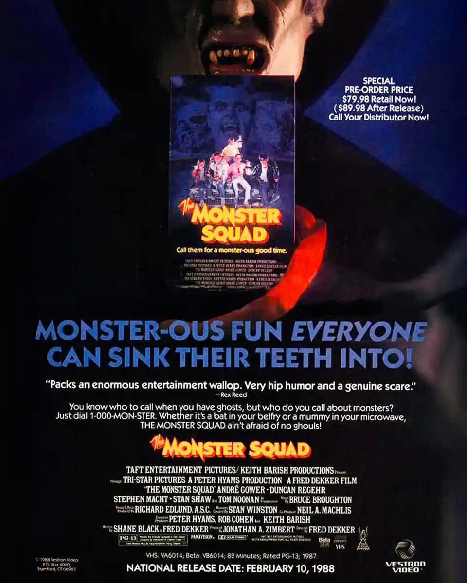 A promotional poster for the 1987 VHS release of 'The Monster Squad' features a vampire with fangs holding a VHS cover of…