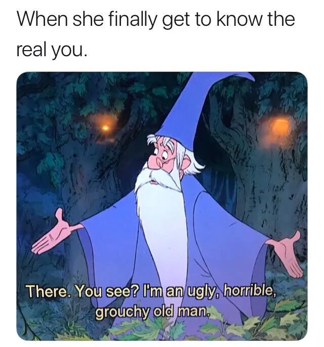 An animated image of the wizard Merlin from Disney's 'The Sword in the Stone' standing in a dark forest with glowing orbs in…