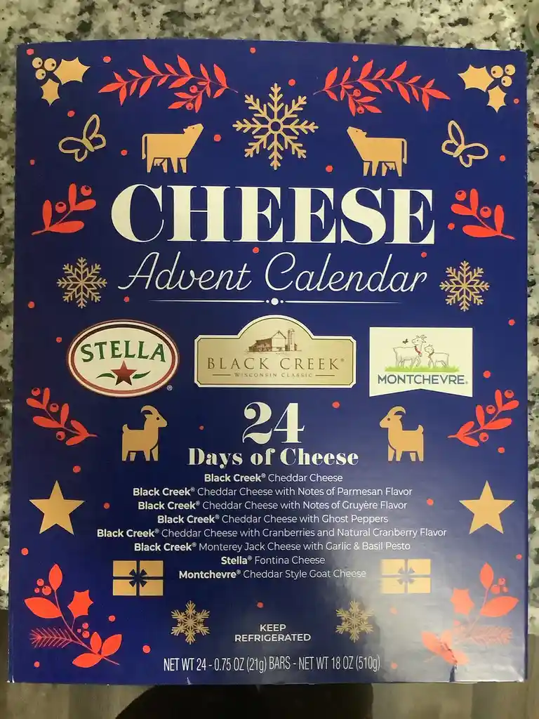 A blue cheese advent calendar box decorated with red and gold holiday motifs like snowflakes, holly, and goats. It features…