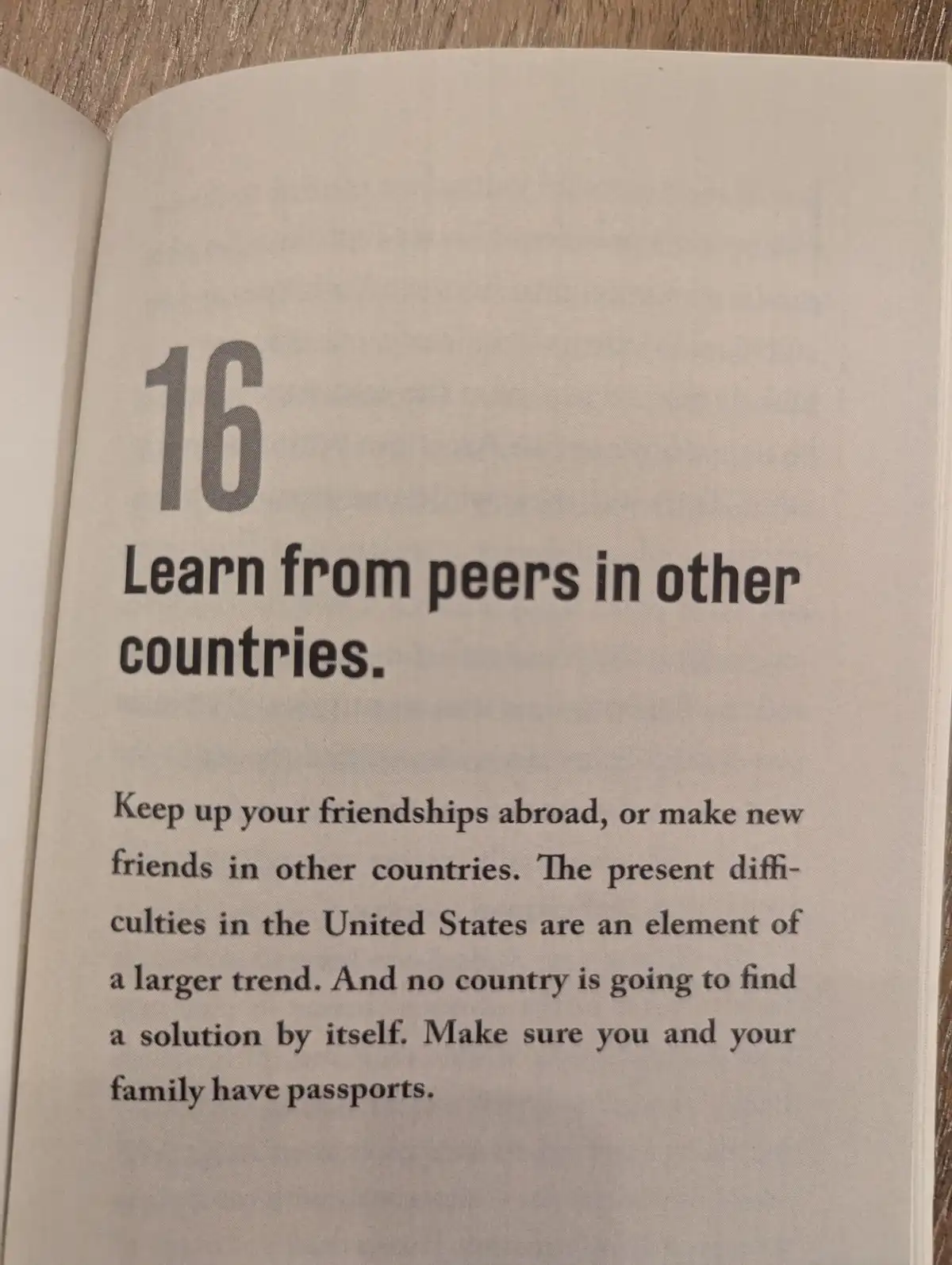 A close-up photo of an open book page showing advice number 16: 'Learn from peers in other countries.' The text advises…