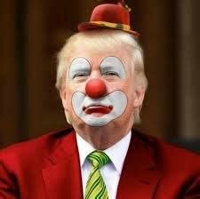 A man with white face paint, a red nose, and red clown makeup around his eyes and mouth wears a red suit, green tie, and a…