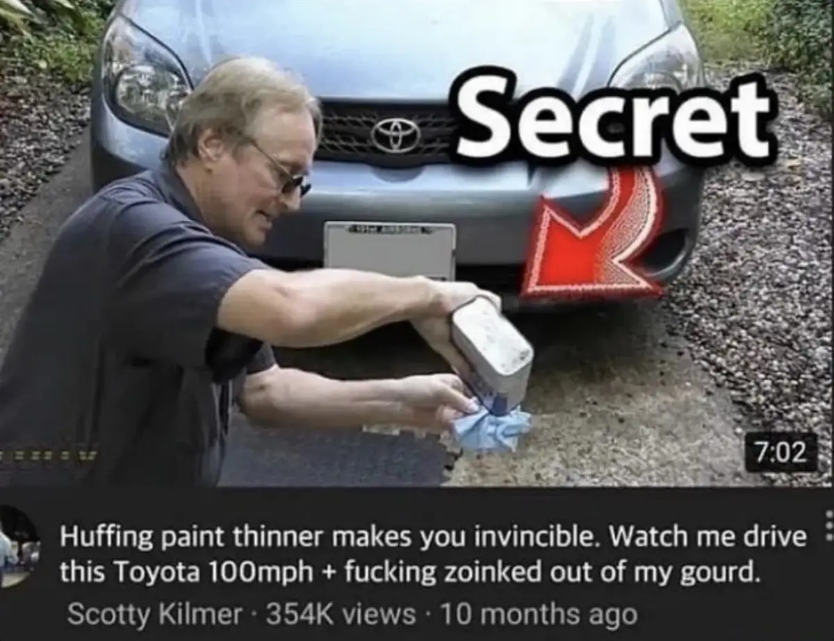 A man in a dark shirt and glasses is shown kneeling in front of a silver Toyota, holding a can of paint thinner and a rag…