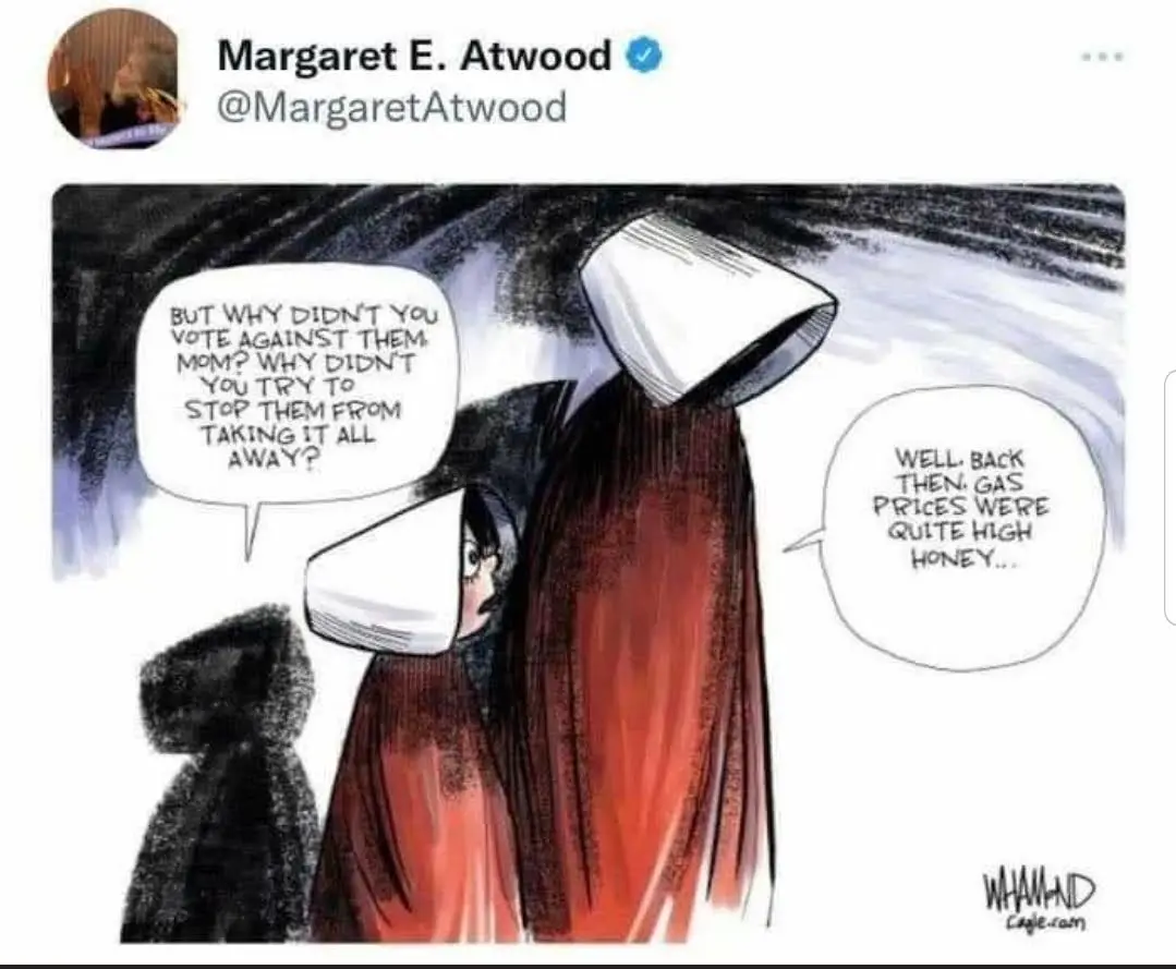 A cartoon depicts two figures in red cloaks and white bonnets, resembling characters from 'The Handmaid's Tale'. The smaller…
