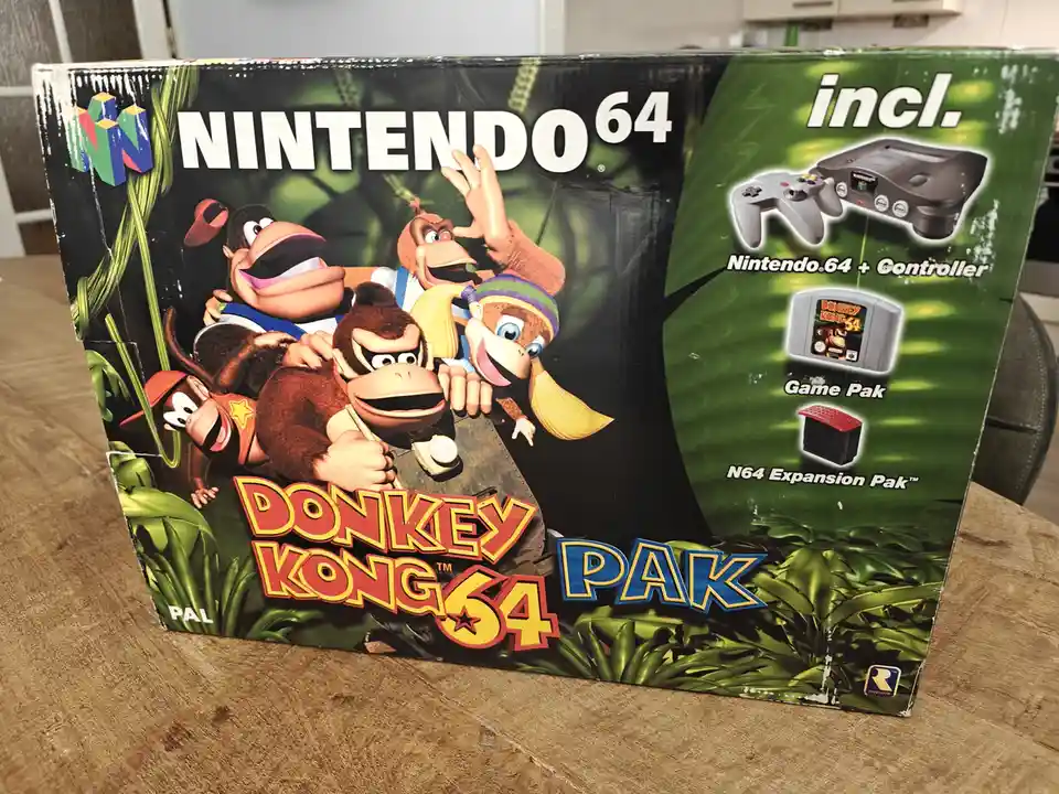 A photo of a worn Nintendo 64 'Donkey Kong 64 PAK' game bundle box, showing the characters Donkey Kong, Diddy Kong, and…
