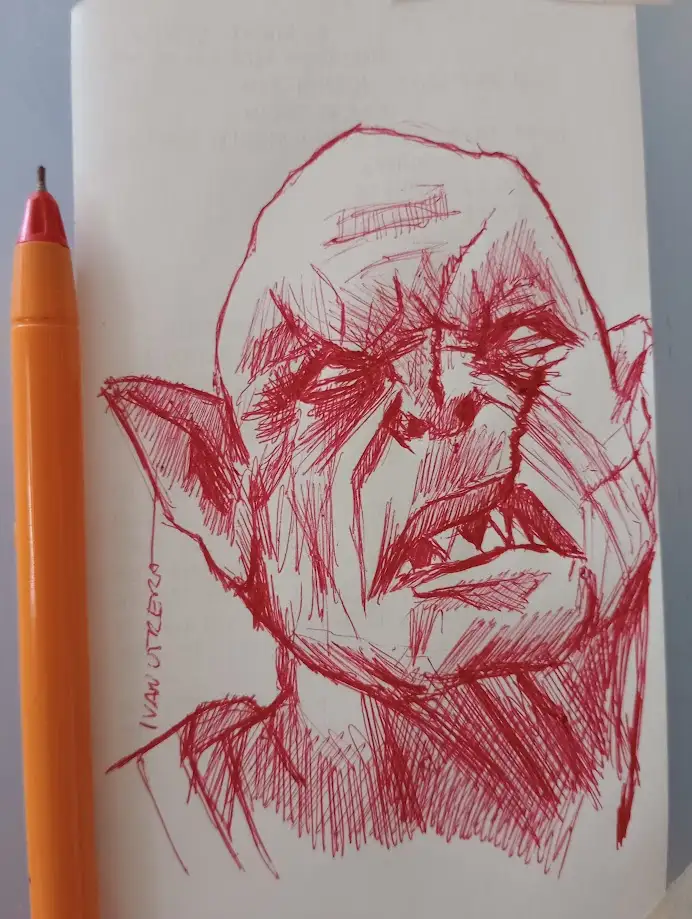 A red ink sketch on white paper depicts a grotesque, angry-looking goblin-like creature with pointed ears, sharp teeth, and…