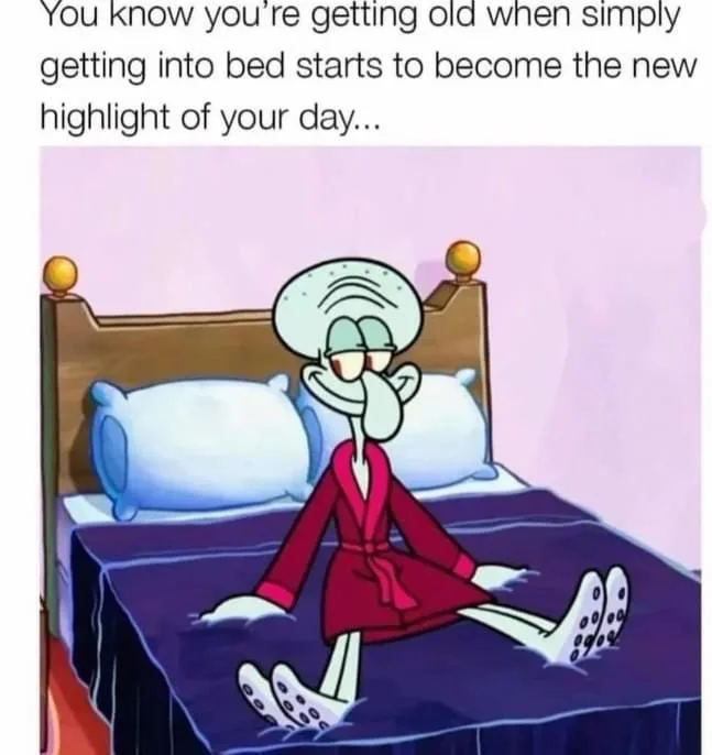 A cartoon squid character, Squidward from SpongeBob SquarePants, sits on a bed wearing a red robe, looking tired and…