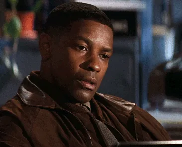 six sequential frames show actor Denzel Washington in a brown leather jacket, transitioning from a serious, slightly…